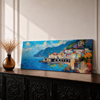 Panoramic Mediterranean coastal painting of the Amalfi Coast featuring colorful hillside houses overlooking bright blue sea. A stone harbor with arches and boats sits along the shoreline while mountains rise in the background beneath a clear sky with scattered clouds across the wide horizontal seaside composition.