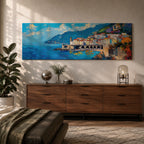 Panoramic Mediterranean coastal painting of the Amalfi Coast featuring colorful hillside houses overlooking bright blue sea. A stone harbor with arches and boats sits along the shoreline while mountains rise in the background beneath a clear sky with scattered clouds across the wide horizontal seaside composition.