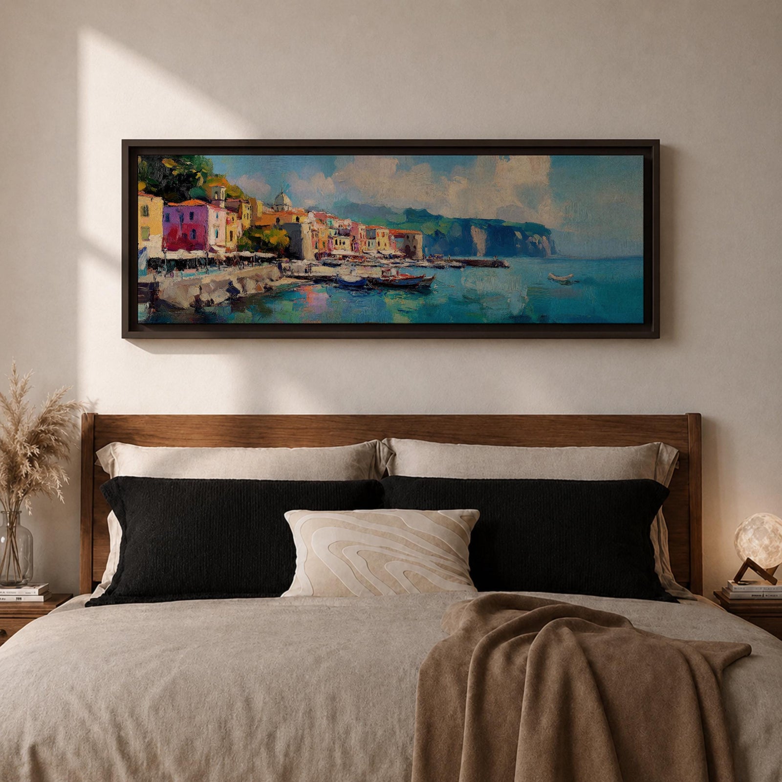 Panoramic Mediterranean harbor village painting featuring colorful seaside houses along a stone waterfront with small fishing boats resting in calm blue water. Soft clouds drift above distant cliffs and green hills while textured brushstrokes capture reflections and gentle movement across the wide coastal scene.
