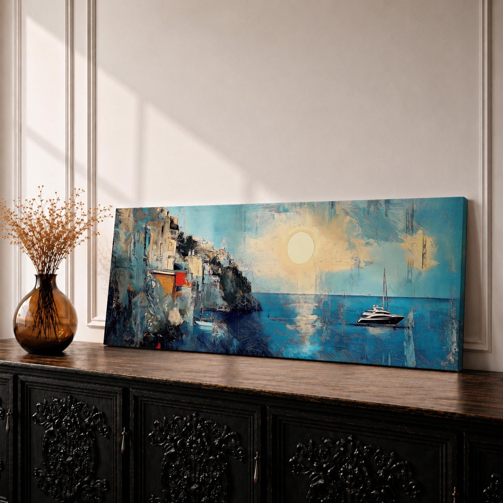 Panoramic Mediterranean coastal painting showing white cliffside houses overlooking deep blue sea at sunset. A sailboat drifts across calm water while sunlight reflects across the horizon and textured brushstrokes form dramatic rocky cliffs and coastal architecture in the wide horizontal seaside composition.