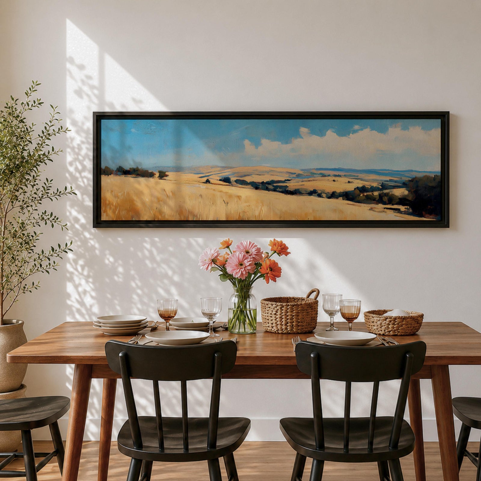 Panoramic wheat field landscape painting showing rolling golden farmland stretching across hills beneath a bright blue sky with scattered clouds. Textured brushstrokes depict tall wheat grasses in the foreground leading toward layered countryside fields, tree clusters, and distant hills across the wide rural horizon.