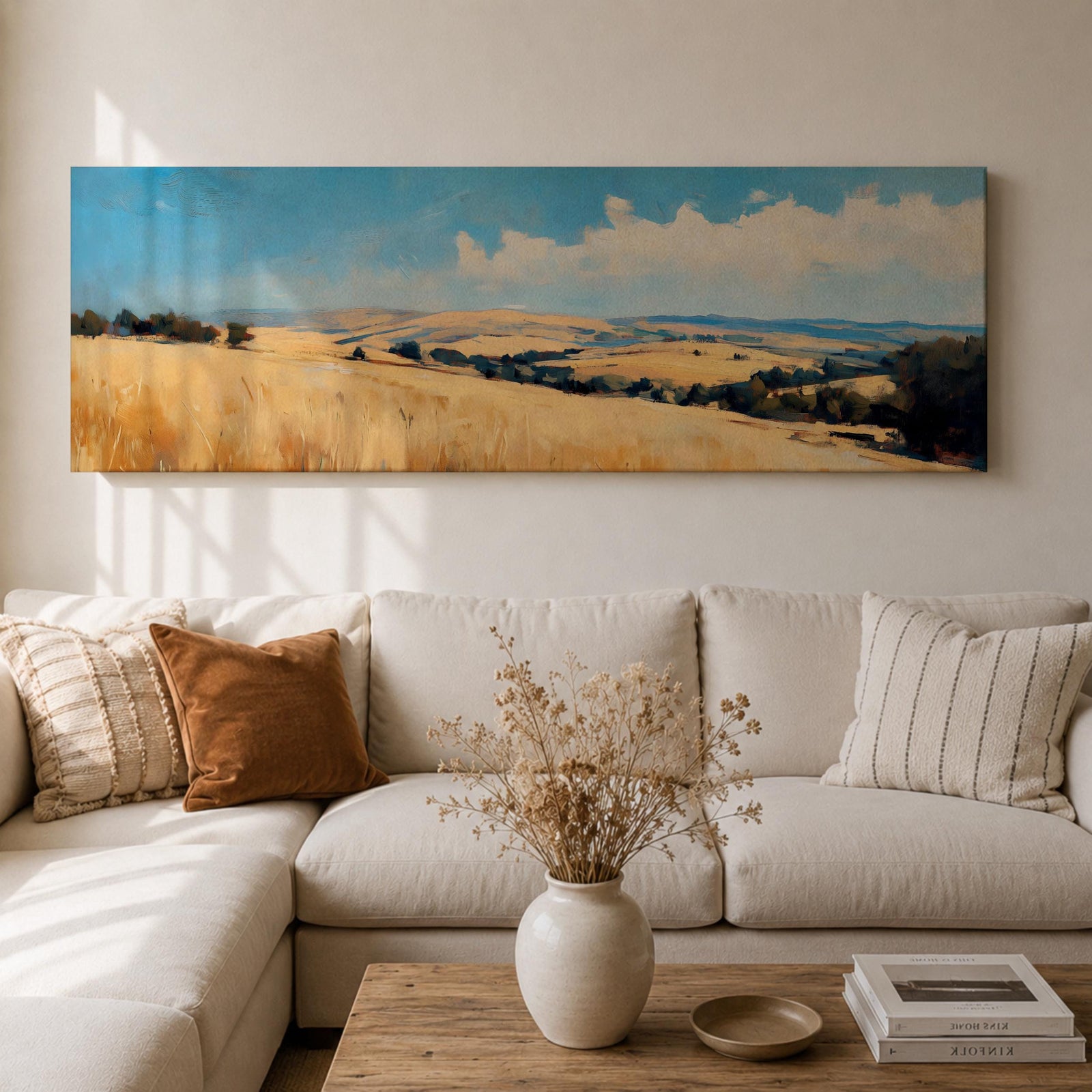 Panoramic wheat field landscape painting showing rolling golden farmland stretching across hills beneath a bright blue sky with scattered clouds. Textured brushstrokes depict tall wheat grasses in the foreground leading toward layered countryside fields, tree clusters, and distant hills across the wide rural horizon.