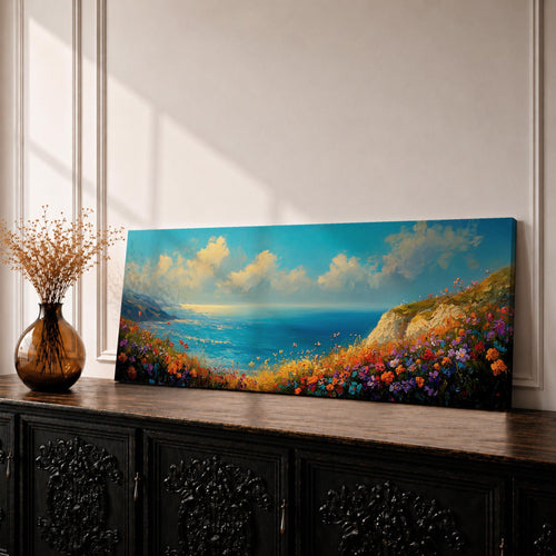 Panoramic coastal landscape painting of colorful wildflowers blooming along a seaside cliff overlooking a bright blue ocean. Vibrant pink, orange, purple, and yellow flowers fill the foreground while rolling waves and distant coastline stretch beneath a wide sky with soft clouds in a luminous horizontal composition.