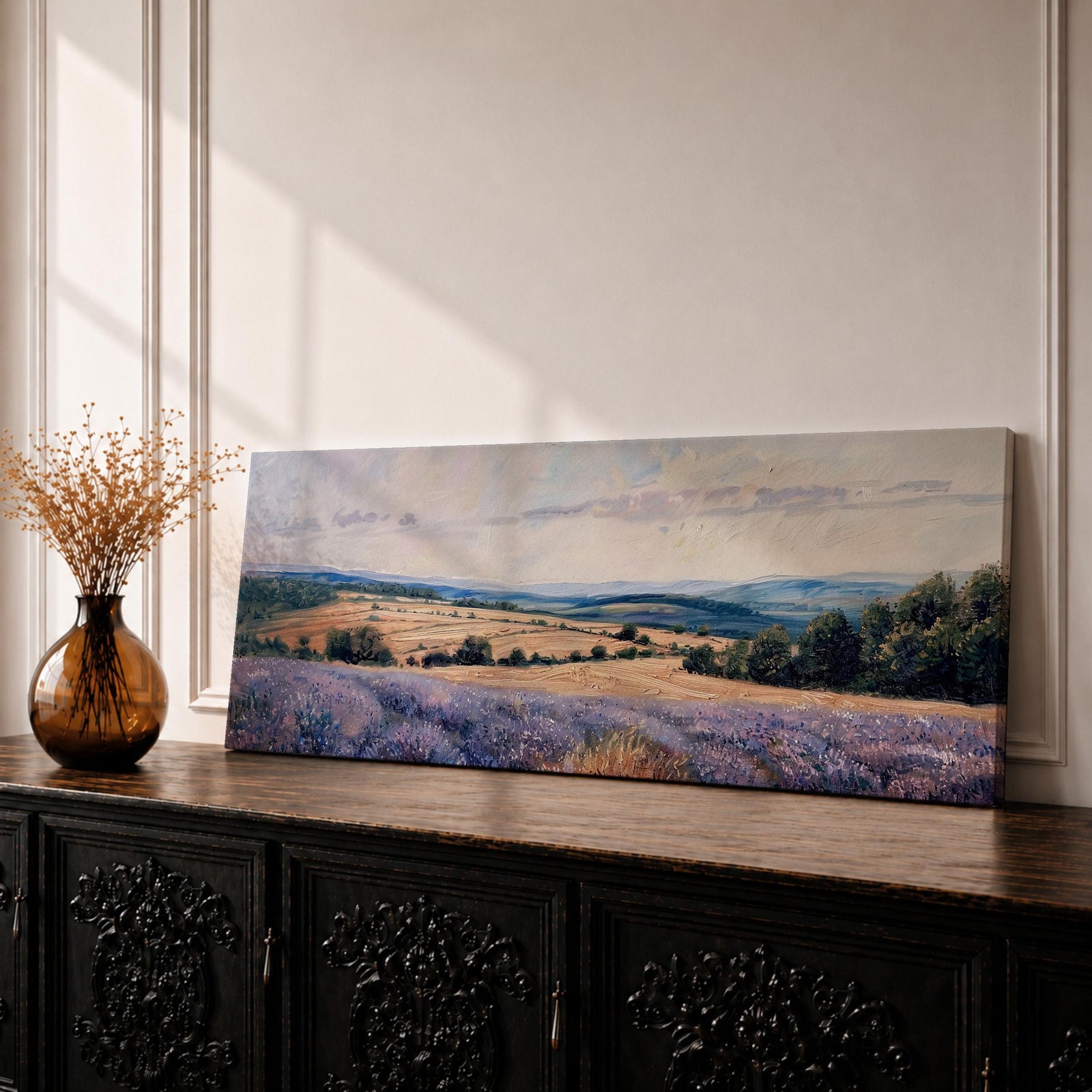 Panoramic lavender meadow landscape painting showing rows of purple wildflowers stretching across rolling countryside fields. Soft textured brushstrokes depict lavender blooms in the foreground leading toward golden farmland, scattered trees, and distant blue hills beneath a calm sky with light clouds across the wide horizon.