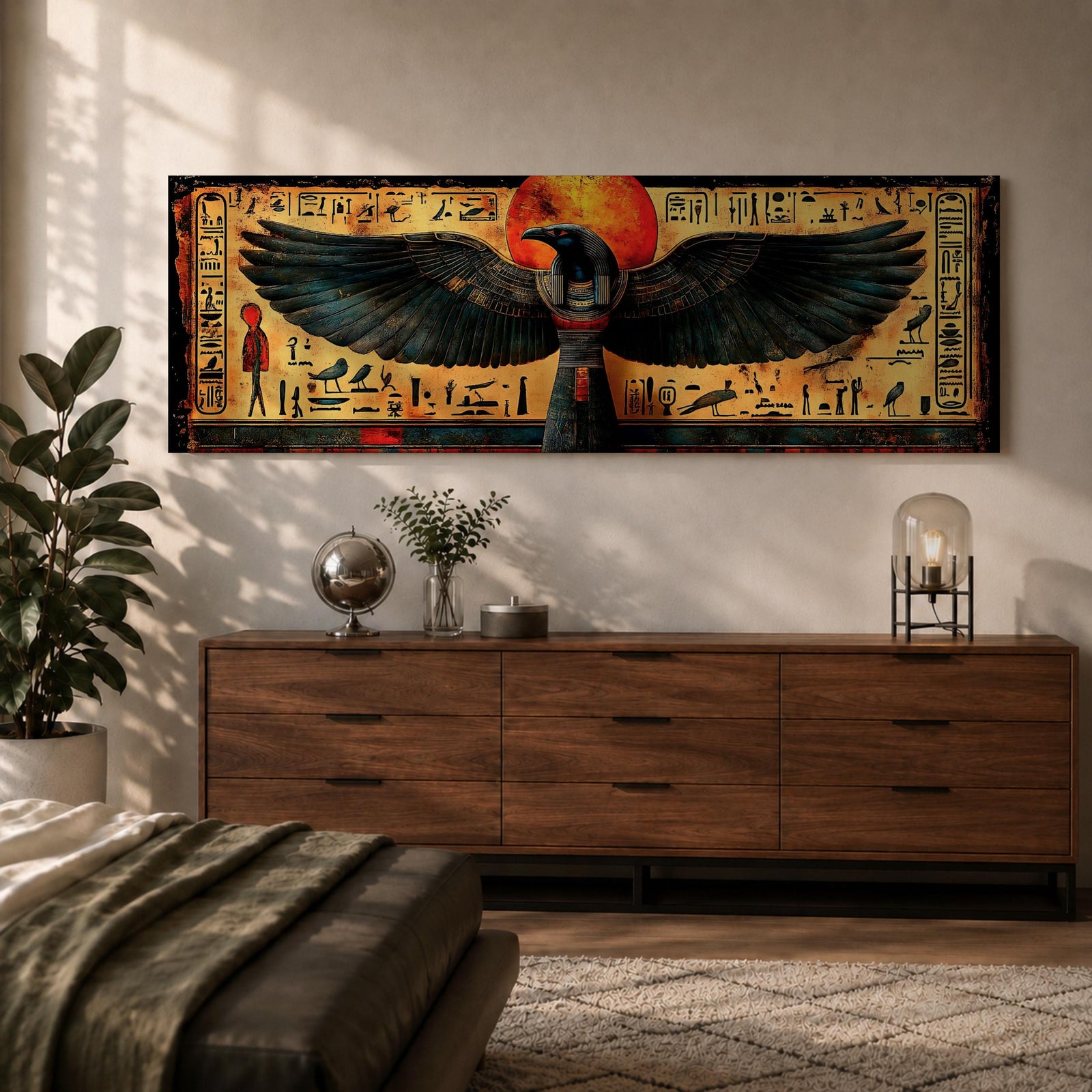 Panoramic ancient Egyptian style artwork featuring the falcon headed god Horus with wide outstretched wings beneath a glowing red sun disk. Hieroglyphic symbols and figures frame the composition while textured gold and dark tones highlight the wings and central deity across the wide symmetrical scene.