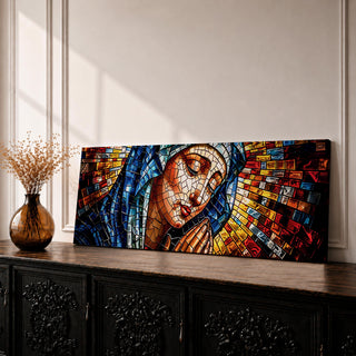 Panoramic stained glass style artwork of the Virgin Mary with closed eyes and folded hands in prayer. Colorful mosaic tiles form her blue veil and warm skin tones while radiant red gold and blue glass pieces spread outward like a halo creating a luminous sacred composition.