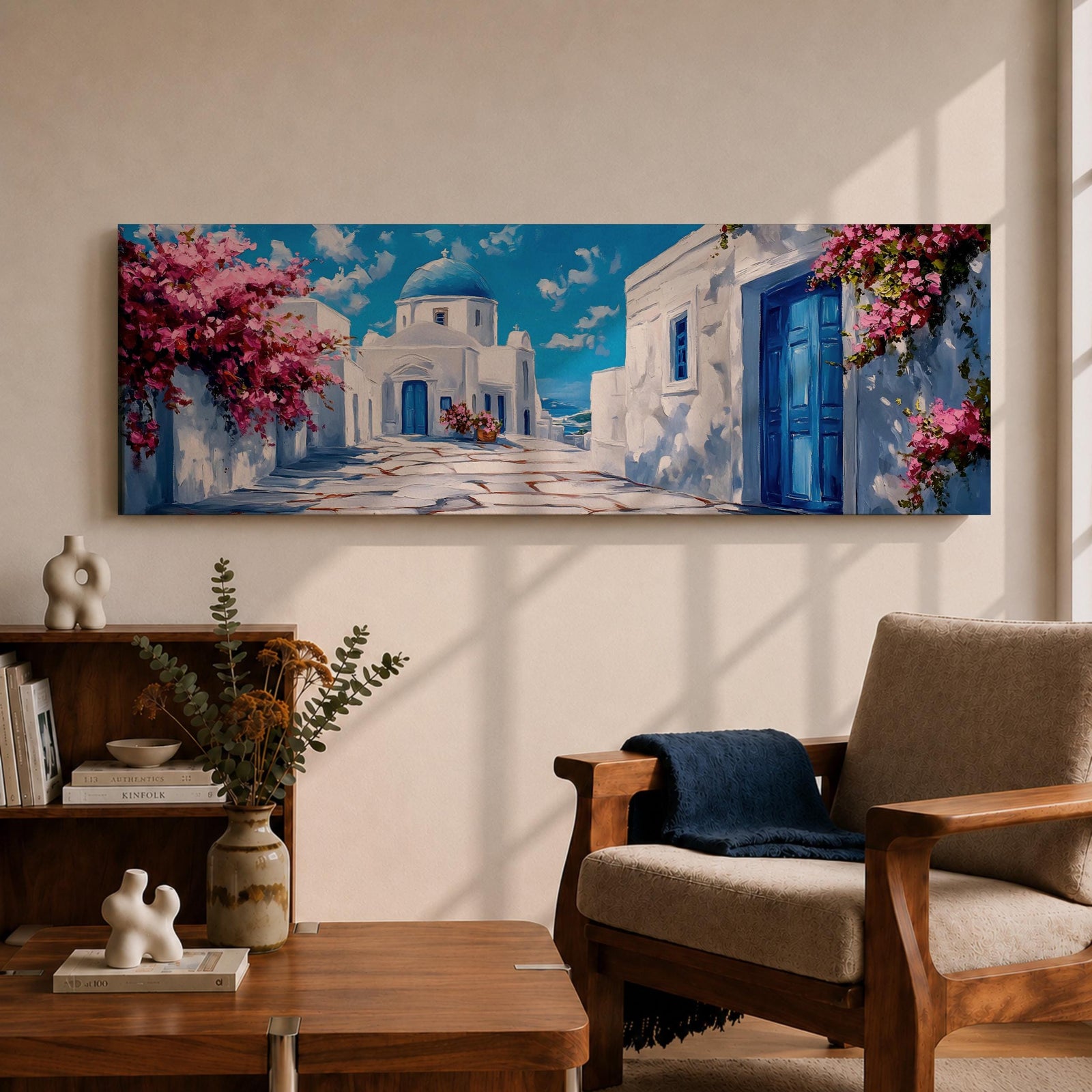 Panoramic painting of a Santorini village featuring whitewashed buildings with blue doors and a domed church along a sunlit stone pathway. Pink bougainvillea flowers frame the scene while bright blue sky and distant Aegean Sea appear beyond the island architecture across the wide composition.