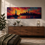 Panoramic cityscape painting showing the Statue of Liberty standing in the harbor with the New York City skyline stretching across the horizon, including tall skyscrapers and One World Trade Center, illuminated by a dramatic sunset sky filled with vibrant red, orange, and blue clouds reflected in the water.