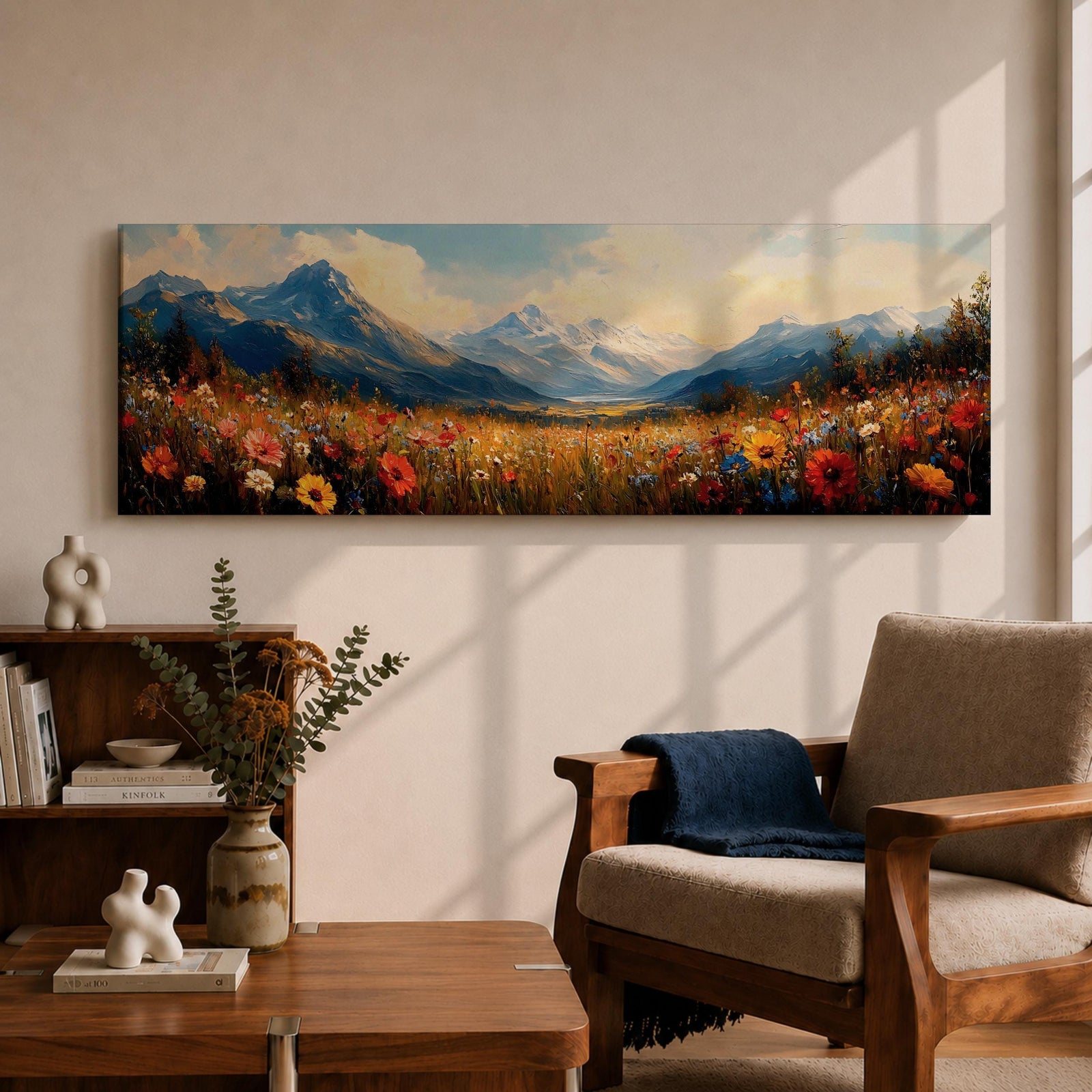 Panoramic landscape painting depicting a wide alpine meadow filled with colorful wildflowers in the foreground leading toward distant snow capped mountains, with rolling hills and soft clouds above, rendered in warm natural tones and expressive brushstrokes forming a sweeping scenic mountain vista.