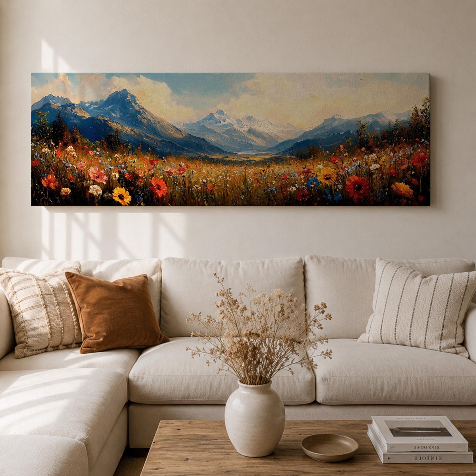 Panoramic landscape painting depicting a wide alpine meadow filled with colorful wildflowers in the foreground leading toward distant snow capped mountains, with rolling hills and soft clouds above, rendered in warm natural tones and expressive brushstrokes forming a sweeping scenic mountain vista.