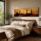 Panoramic artwork depicting a dramatic skyline of mosque domes and tall minarets silhouetted against a glowing golden sunset sky, with warm amber and orange tones diffused through atmospheric haze creating a striking Islamic architectural horizon.