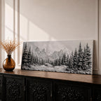Panoramic monochrome landscape artwork depicting snow covered mountains and a dense pine forest with a winter valley scene rendered in black and white tones.