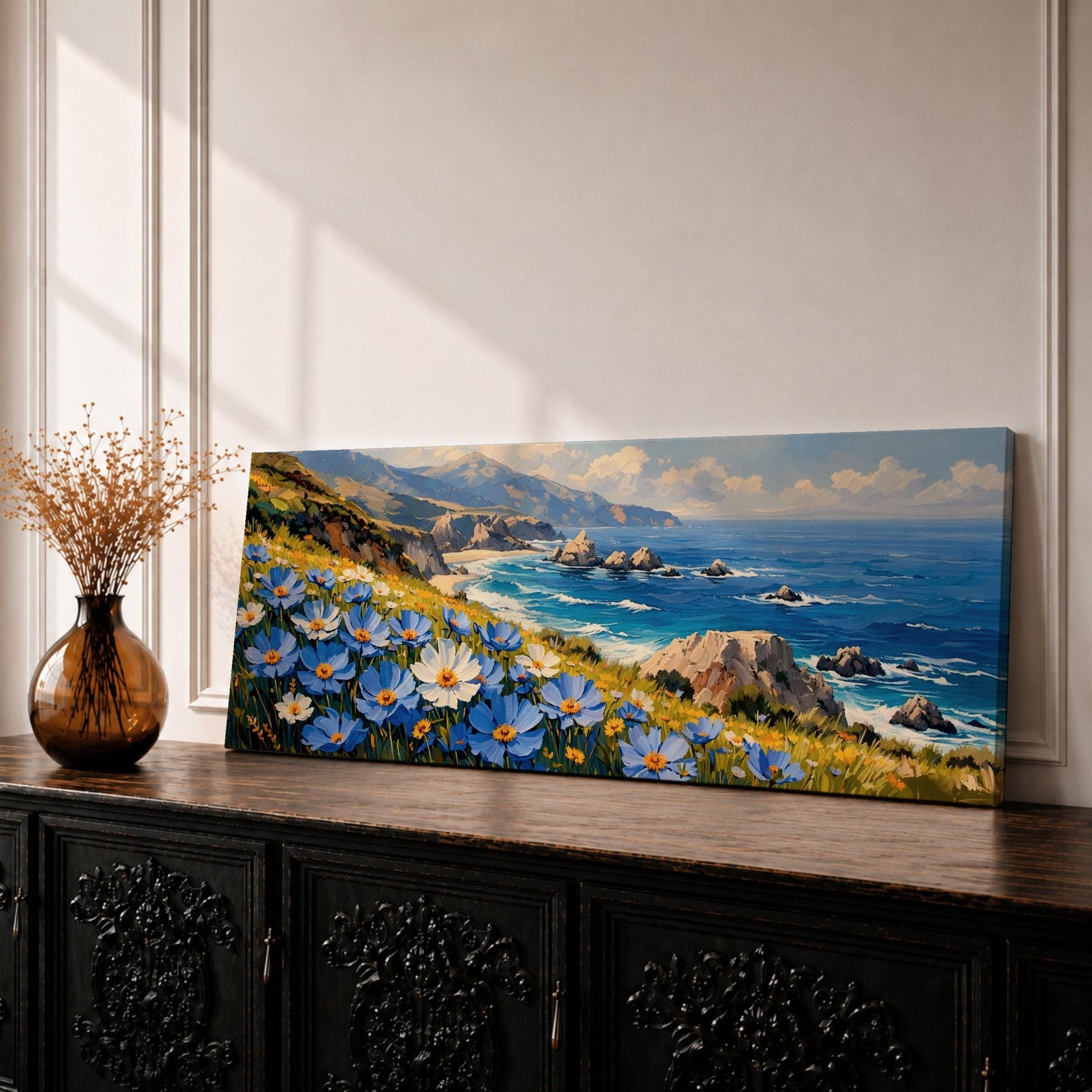 A panoramic coastal landscape painting showing blue and white wildflowers blooming along a grassy cliff overlooking a rocky shoreline and deep blue ocean waves, with distant mountains and scattered sea stacks beneath a bright sky stretching across the wide horizontal composition.