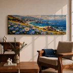 A panoramic coastal landscape painting showing blue and white wildflowers blooming along a grassy cliff overlooking a rocky shoreline and deep blue ocean waves, with distant mountains and scattered sea stacks beneath a bright sky stretching across the wide horizontal composition.