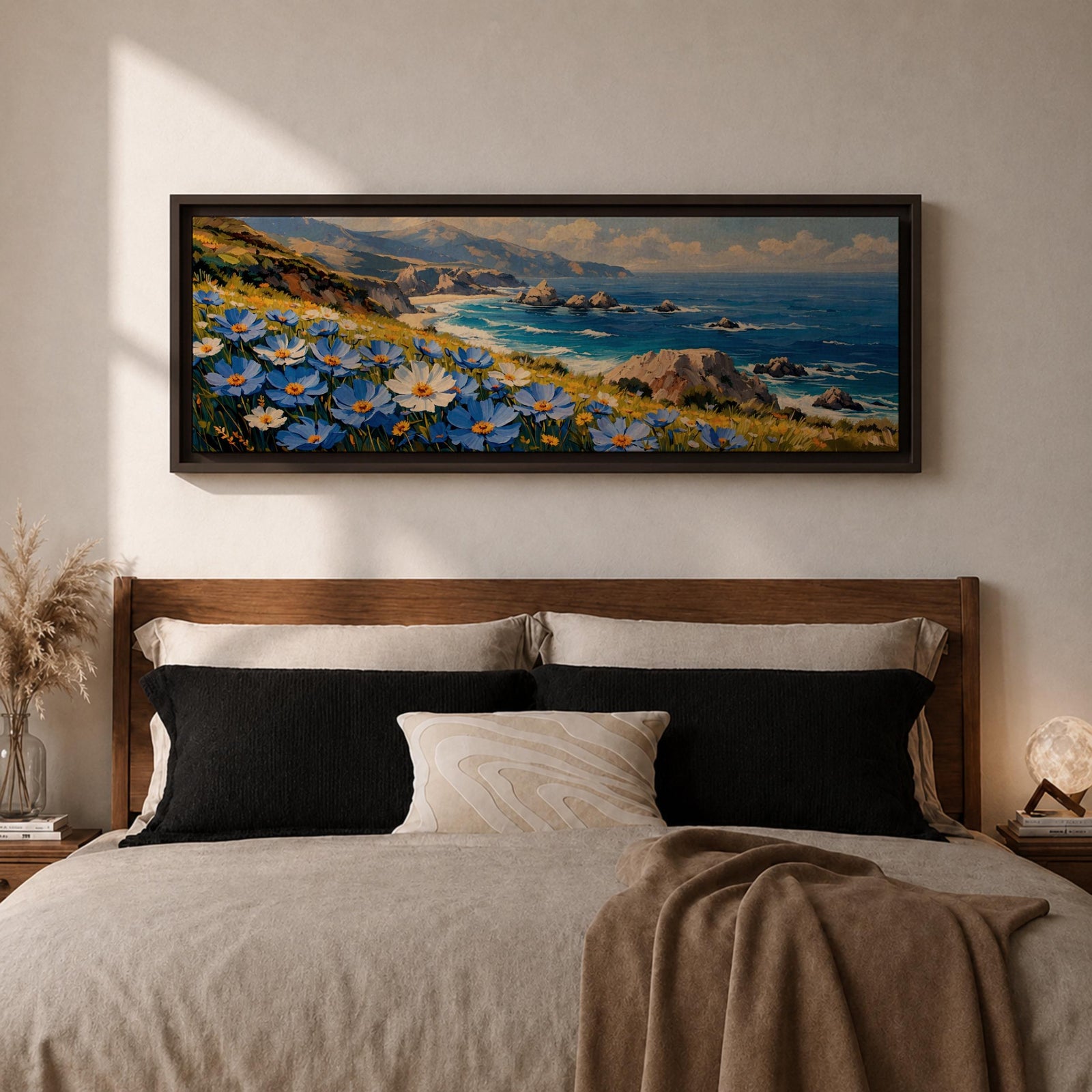 A panoramic coastal landscape painting showing blue and white wildflowers blooming along a grassy cliff overlooking a rocky shoreline and deep blue ocean waves, with distant mountains and scattered sea stacks beneath a bright sky stretching across the wide horizontal composition.