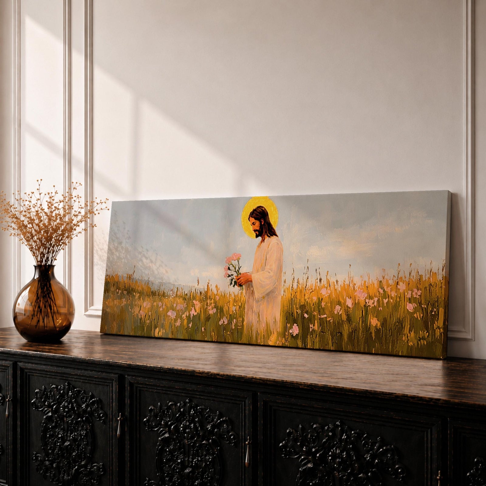 A long panoramic painting of Jesus standing in a wildflower meadow holding delicate pink flowers, wearing a flowing white robe with a golden halo behind his head. Tall grasses and blooming flowers stretch across the landscape under a soft sky, creating a peaceful Christian scene centered on Christ in nature.