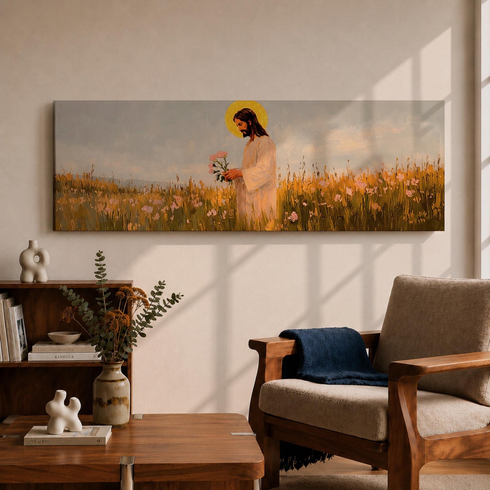 A long panoramic painting of Jesus standing in a wildflower meadow holding delicate pink flowers, wearing a flowing white robe with a golden halo behind his head. Tall grasses and blooming flowers stretch across the landscape under a soft sky, creating a peaceful Christian scene centered on Christ in nature.