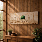 A long panoramic painting of the Green Dome of Masjid Nabawi in Medina rising above elegant mosque arches and courtyards. Tall slender minarets frame the sacred structure while soft beige and golden tones create a historic Islamic architectural scene centered on the iconic green dome in a wide horizontal composition.