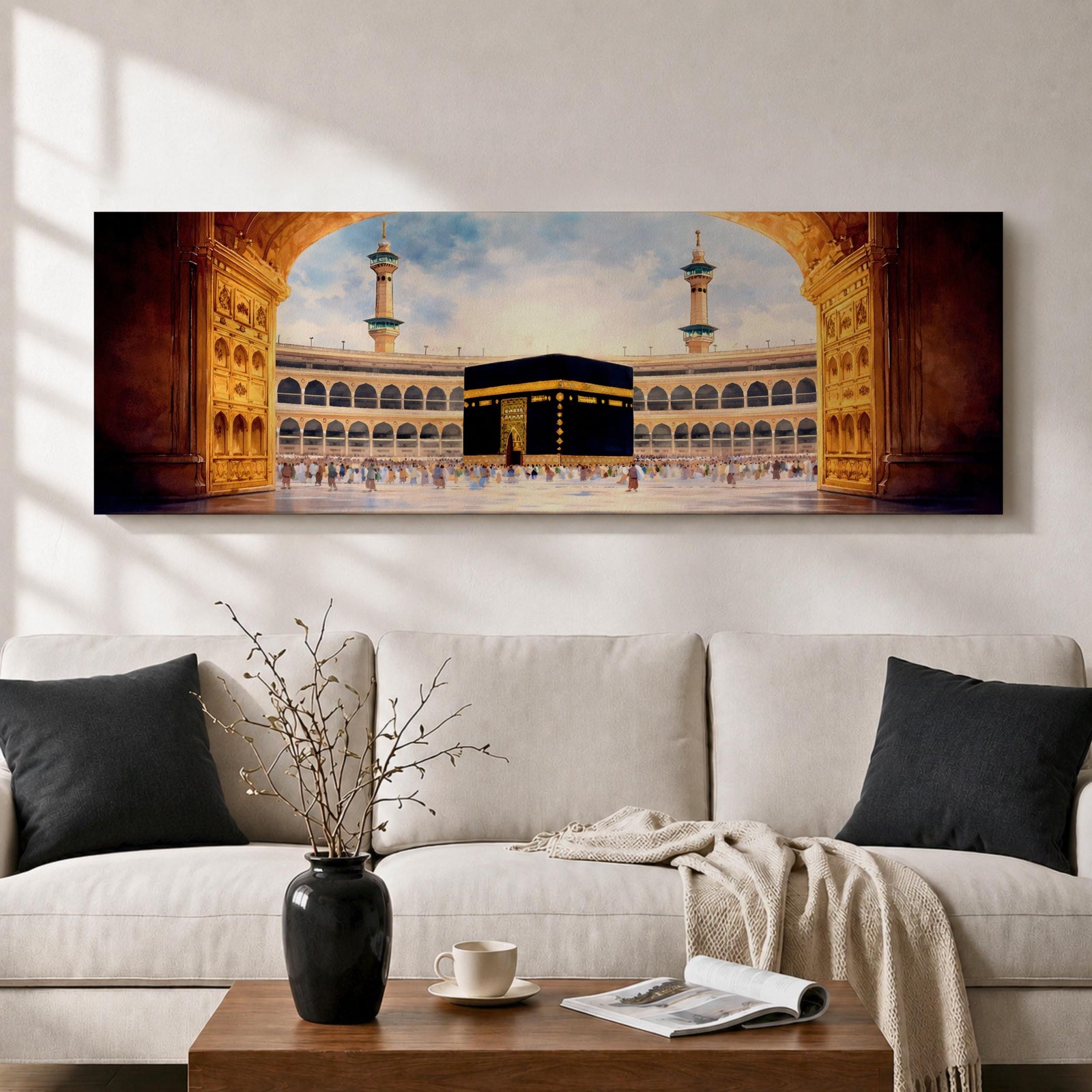 A long panoramic artwork depicting the Kaaba at the center of Masjid Al Haram in Mecca framed by grand mosque arches and tall minarets. The sacred black cube stands in the courtyard while pilgrims gather around it, creating a wide horizontal composition highlighting the holy Islamic sanctuary.