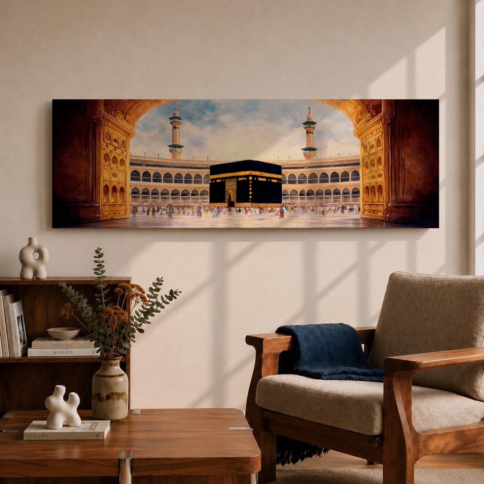 A long panoramic artwork depicting the Kaaba at the center of Masjid Al Haram in Mecca framed by grand mosque arches and tall minarets. The sacred black cube stands in the courtyard while pilgrims gather around it, creating a wide horizontal composition highlighting the holy Islamic sanctuary.