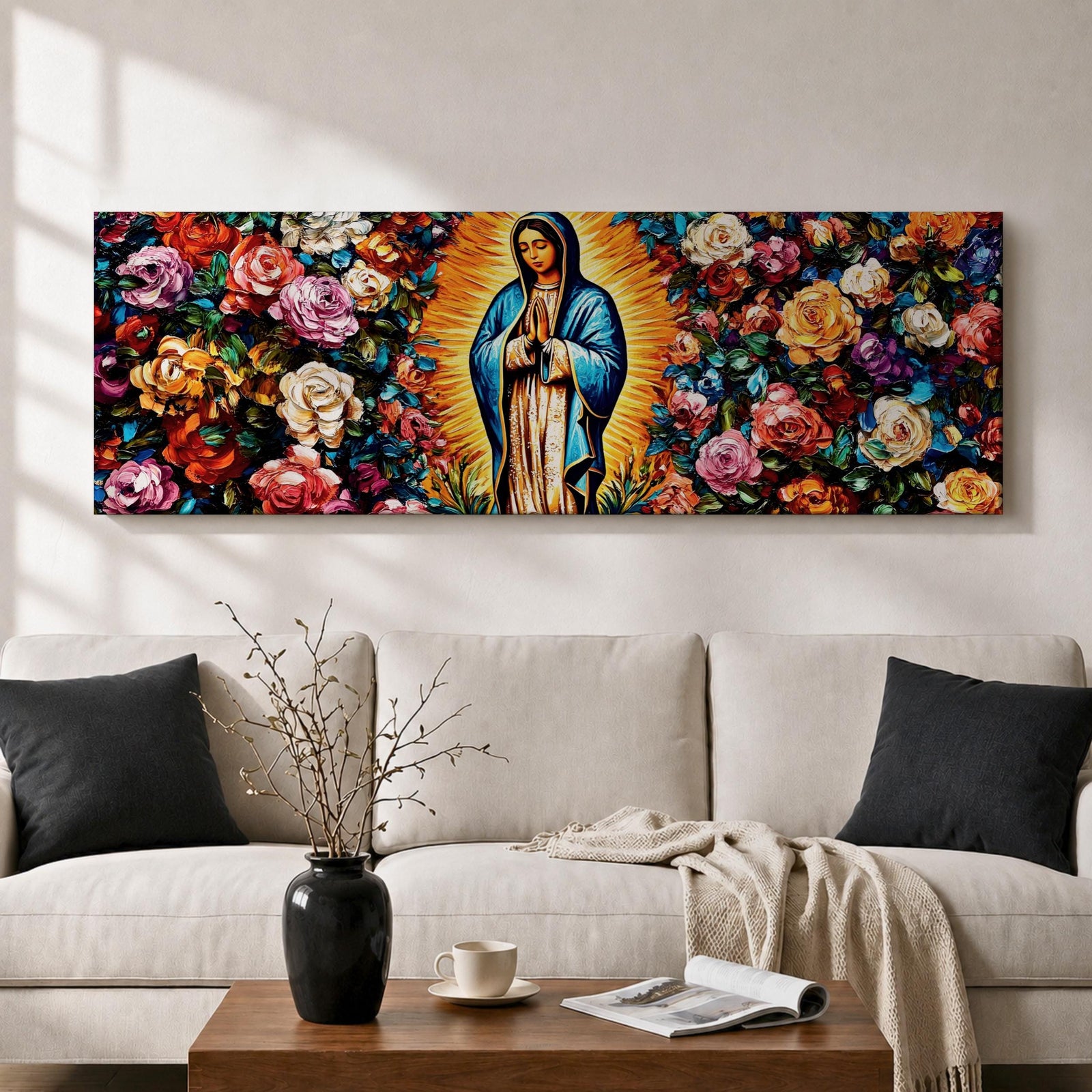 A long panoramic painting of Mary of Guadalupe standing in prayer with hands folded and head bowed, surrounded by radiant golden rays. She wears a blue mantle over a rose colored gown while vibrant roses and colorful flowers fill the background, creating a devotional Catholic Marian image across a wide horizontal composition.