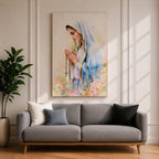 A watercolor style framed canvas depicting Virgin Mary in profile, wearing a blue and white veil with gold trim, holding a rosary and praying, surrounded by soft floral colors and a gentle light background.