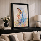 A watercolor style framed canvas depicting Virgin Mary in profile, wearing a blue and white veil with gold trim, holding a rosary and praying, surrounded by soft floral colors and a gentle light background.