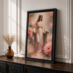 A framed canvas painting depicting the Immaculate Conception showing the Virgin Mary standing with open arms surrounded by soft pink flowers and golden accents, rendered in a realistic style with delicate flowing robes and a serene expression.