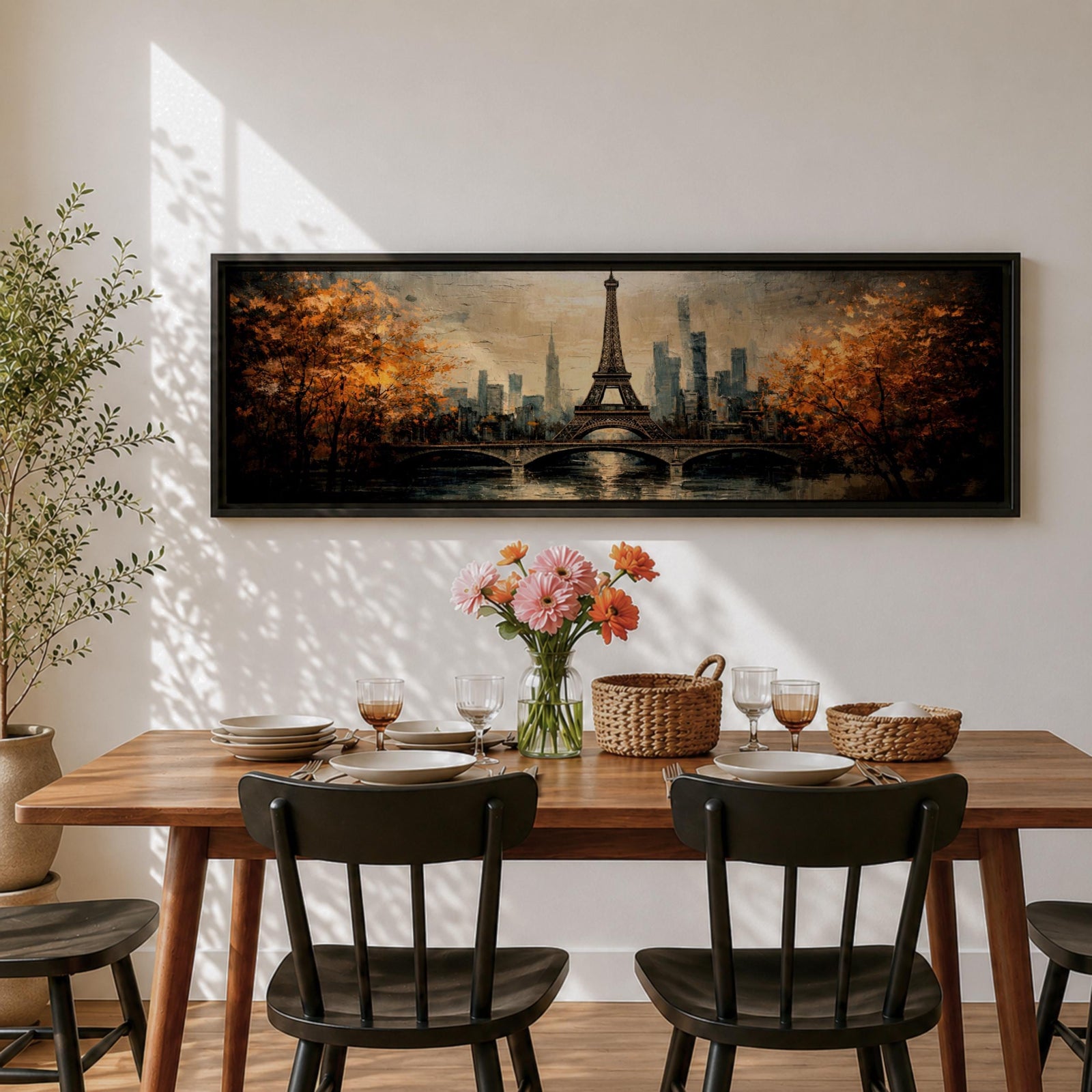 A long narrow panoramic painting depicts the Eiffel Tower rising above a river with an arched bridge in the foreground, surrounded by autumn trees and a distant city skyline, rendered in textured brushstrokes with warm golden tones and soft reflections that create depth and a romantic atmospheric cityscape.