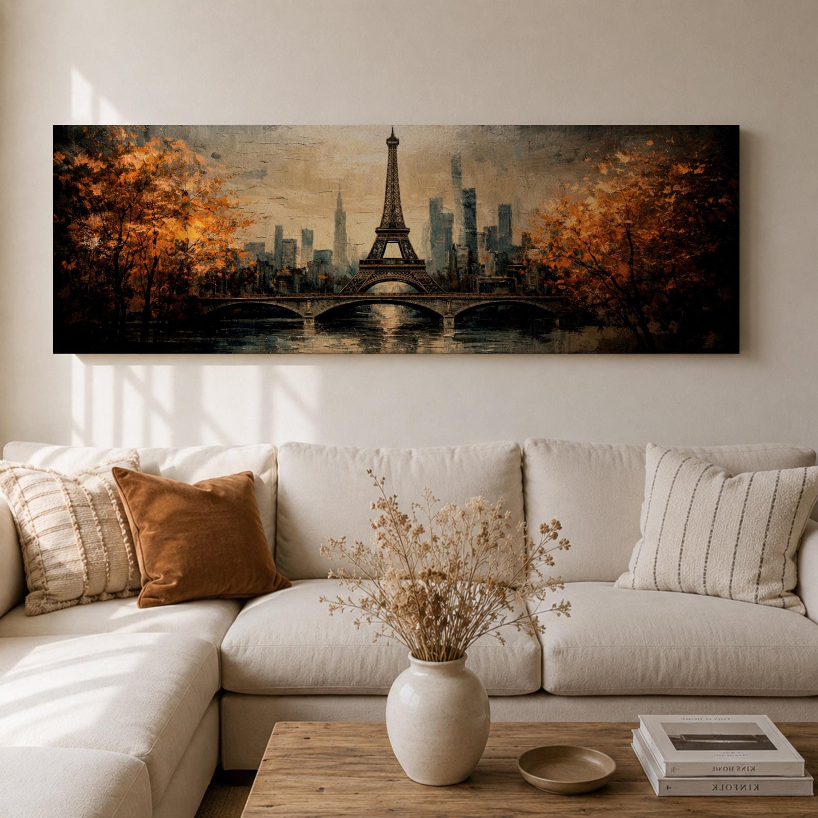 A long narrow panoramic painting depicts the Eiffel Tower rising above a river with an arched bridge in the foreground, surrounded by autumn trees and a distant city skyline, rendered in textured brushstrokes with warm golden tones and soft reflections that create depth and a romantic atmospheric cityscape.