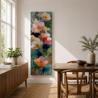 A tall, narrow vertical painting of soft pastel poppy flowers in shades of blush pink, coral, cream, and muted yellow, layered with textured brushstrokes and accented by hints of gold against a cool blue abstract background, with delicate stems and leaves creating a balanced contemporary floral composition.